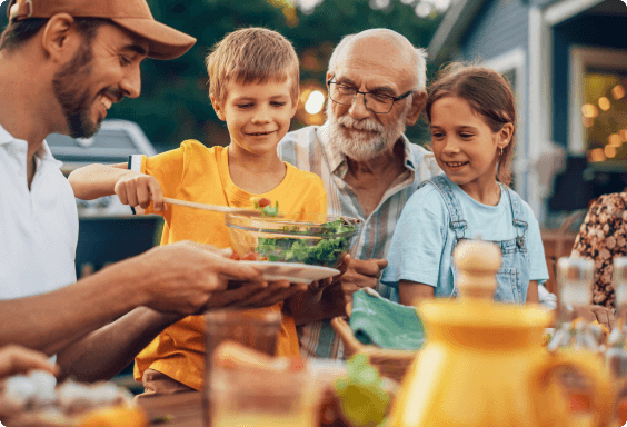 multi-generational family outside eating dinner on a calm summer evening